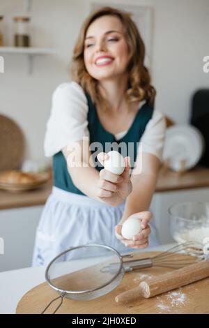 Ragazza dolciaria che tiene le uova di pollo nelle sue mani Foto Stock