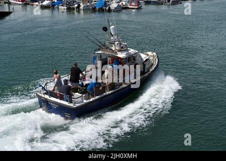 Charter barca da pesca Dobhran di ritorno a Littlehampton sul fiume Arun pieno di pescatori e donna. Foto Stock