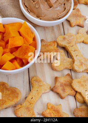 biscotti biologici fatti in casa per cani e ingredienti su legno crudo con spazio copia Foto Stock