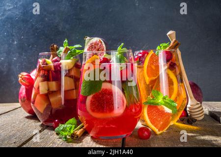 Tradizionale autunno inverno bere caldo piccante sangria - rosso, rosa, bianco. Con sidro, vino rosso rosa, mele, arance, melograno, mirtillo, prugna, fichi, Foto Stock