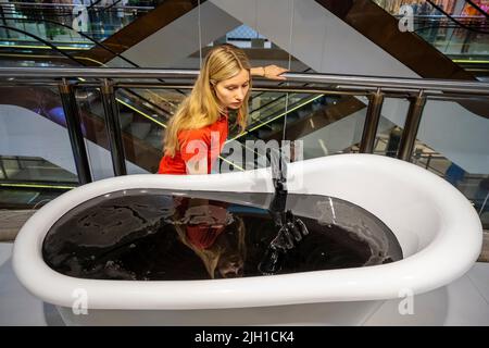 Londra, Regno Unito. 14 luglio 2022. Un membro dello staff vede 'Deep Float', 2017, di Monira al Qadir in anteprima di SUPERFUTURES, una nuova mostra a Selfridges, Oxford Street. 13 grandi opere d'arte immersive su larga scala in esposizione in tutto il negozio e le finestre presentano le visioni degli artisti contemporanei per il futuro. La mostra fa parte dell’iniziativa Selfridges chiamata “reinventing retail” e si svolge fino al 15 ottobre 2022. Credit: Stephen Chung / Alamy Live News Foto Stock