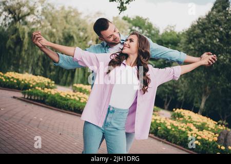 Ritratto di due bella gente allegra tenere le mani ballare hanno buon umore godersi bel tempo all'aperto Foto Stock