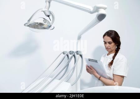 Fidato esperto qualificato felice sorridente medico tenendo appunti con documenti Foto Stock