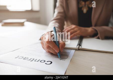 Mano femminile con penna che completa le informazioni personali sul modulo. Donna d'affari che firma contratto redditizio. Foto Stock