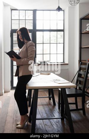 Bella donna di affari che scrive nel suo notebook Foto Stock