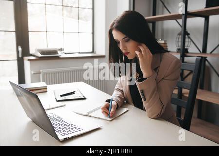 Donna d'affari concentrata che lavora in ufficio Foto Stock