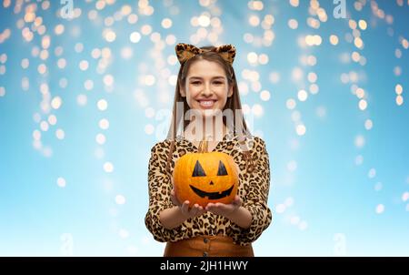 donna in costume di halloween di leopardo con zucca Foto Stock