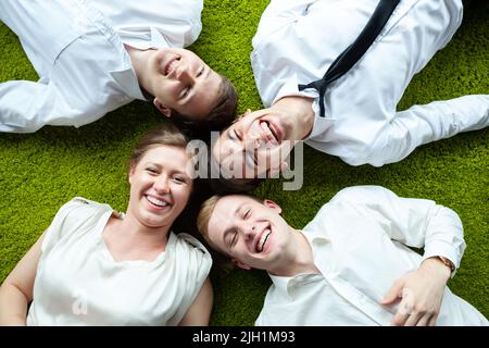 Top Down shot di un gruppo di giovani uomini d'affari che si divertono in un'atmosfera informale. Foto Stock