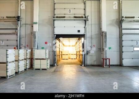 Vista generale dei cancelli di carico all'interno del magazzino. Interno di un magazzino moderno. Processo di caricamento del carrello Foto Stock