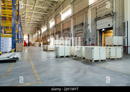 Vista generale dei cancelli di carico all'interno del magazzino. Interno di un magazzino moderno. Processo di caricamento del carrello Foto Stock