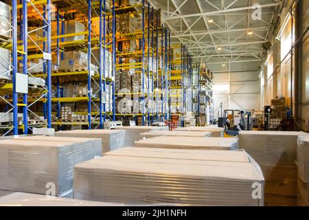 Gruppo di scatole in magazzino. Pallet con scatole di cartone. Interno di un magazzino moderno Foto Stock