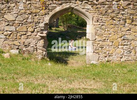 Ragazza meditando da sola in antiche rovine Foto Stock