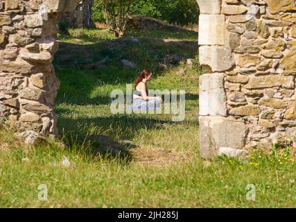 Ragazza meditando da sola in antiche rovine Foto Stock