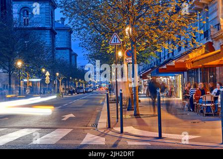 Strade turistiche con caffè e ristoranti a Parigi di notte Foto Stock