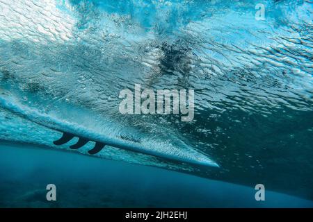 Vista sotto l'acqua dell'onda, surfista su tavola da surf, scatto subacqueo Foto Stock