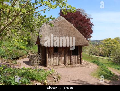 Una caratteristica capanna con tetto di paglia si affaccia sulla campagna inglese Foto Stock