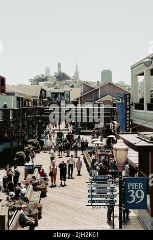 Vista delle persone che esplorano il Molo 39, un centro commerciale e popolare attrazione turistica costruita su un molo di San Francisco. Foto Stock