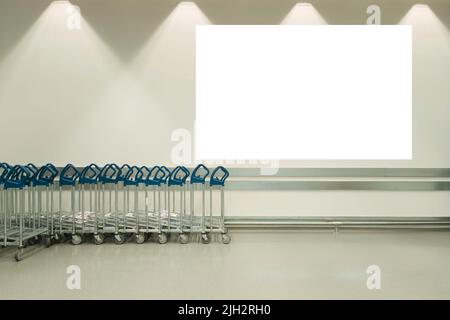 Mock up. Grande cartellone bianco bianco orizzontale sul muro nel supermercato vicino ai carrelli per lo shopping. Bacheca informativa, pubblicità interna Foto Stock