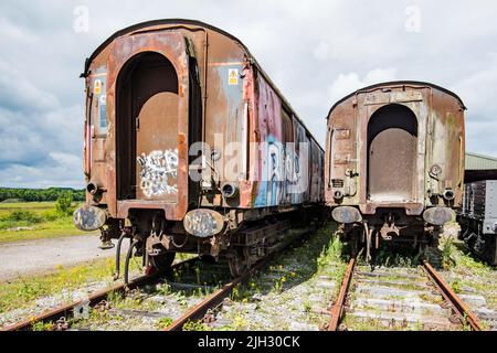 Vecchi carrelli del materiale rotabile in disuso parcheggiati alla stazione di Hellifield in attesa di un ruolo futuro successivo......forse ricambi, rottamazione o addirittura restauro. 14/7/22. Foto Stock