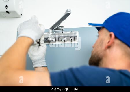 Manuale Installazione e fissaggio del chiudiporta automatico. Manutenzione e assistenza Foto Stock