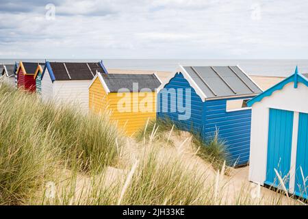 Southwold Beach capanne raffigurate su alcune belle dune di sabbia ricoperte di erba lunga sulla costa del Suffolk. Foto Stock