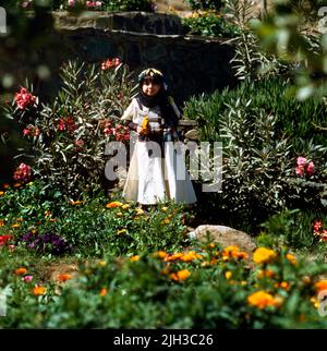 Baha Arabia Saudita ragazza in giardino indossando abiti tradizionali Foto Stock