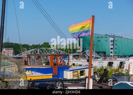Amsterdam, Paesi Bassi - 22 giugno 2022: Bandiera arcobaleno gay su una barca da chiatta sul lungomare Foto Stock