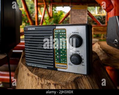 Santa Elena, Antioquia, Colombia - Maggio 17 2022: Radio antica su un tronco di legno Foto Stock