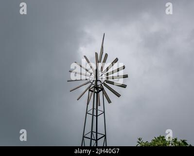 Mulino a vento in esecuzione in un giorno nuvoloso Foto Stock