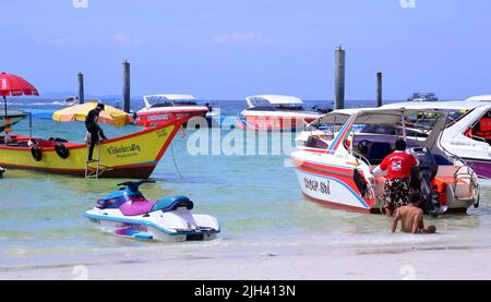 Gli uomini gestiscono barche turistiche in mare sull'isola di Koh Larn, che può essere spelt Ko Larn o Ko Laan o Ko LAN, Thailandia, Asia. Foto Stock