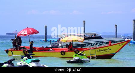 Gli uomini gestiscono barche turistiche in mare sull'isola di Koh Larn, che può essere spelt Ko Larn o Ko Laan o Ko LAN, Thailandia, Asia. Foto Stock