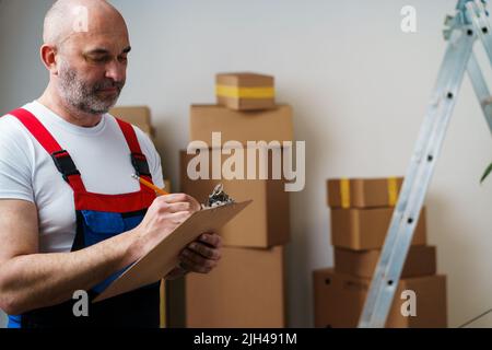 L'uomo di mezza età si mover in uniforme facendo note sugli appunti Foto Stock