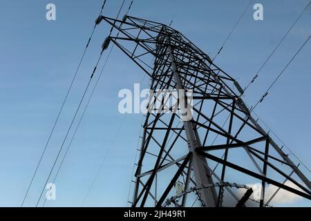 Vista dal basso del pilone elettrico contro il cielo blu profondo con spazio copia Foto Stock