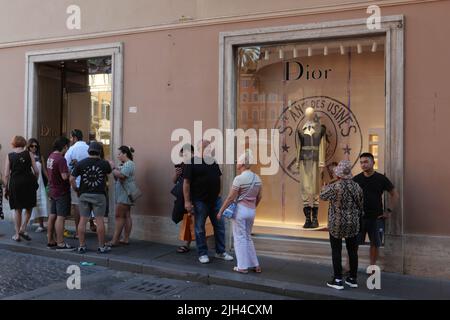 PERSONE IN FILA IN ATTESA DI ENTRARE IN DIOR FASHION BOUTIQUE Foto Stock