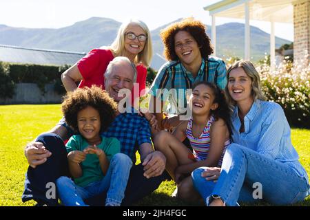 Ritratto di allegro multirazziale famiglia multirazziale godendo tempo libero in cortile in giorno di sole Foto Stock