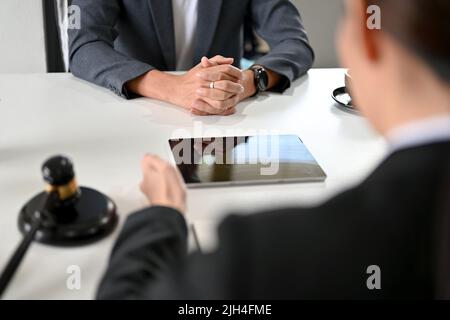 Un avvocato femminile di successo o consulente legale che ha un incontro formale e serio con il suo cliente in ufficio. Immagine ritagliata Foto Stock