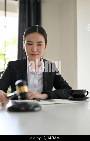 Ritratto, avvocato femminile asiatico di successo in possesso di un martello giudice o gavel giudice in ufficio aula. Avvocato, giudice, avvocato aziendale concetto. Foto Stock