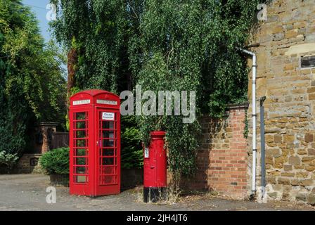 Box telefonico rosso e box postale rosso l'uno accanto all'altro nel villaggio di Spratton, Northamptonshire, Regno Unito Foto Stock