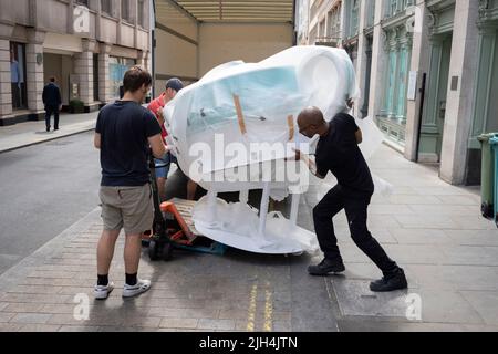 Gli uomini di Delvery scaricano un grande negozio di teapot-tipo da un camion all'ingresso posteriore del rivenditore di lusso Fortnum & Mason, in Jermyn Street, il 14th luglio 2022, a Londra, Inghilterra. Foto Stock