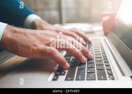 Apertura del computer portatile e digitazione a mani maschili Foto Stock