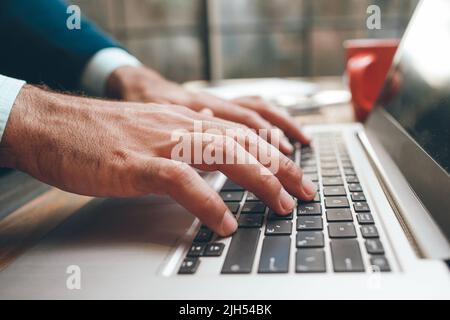Apertura del computer portatile e digitazione a mani maschili Foto Stock