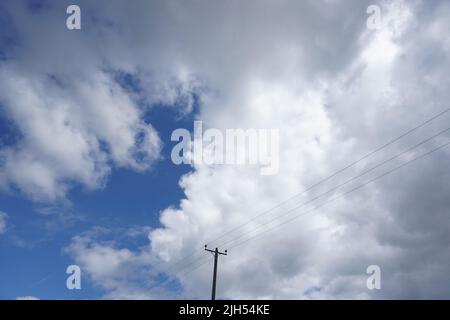 Telegraph Pole contro Blue, cielo nuvoloso Foto Stock