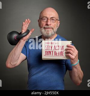 restate attivi, non ritiratevi, ikigai regola - uomo anziano (alla fine del 60s) con ferro kettlebell sta tenendo nota ispiratrice, invecchiamento e stile di vita sano conc. Foto Stock