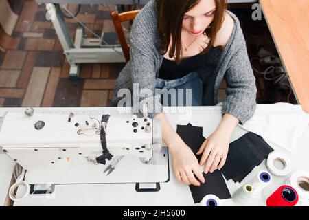 Seamstress lavorazione in vista dall'alto macchina da cucire Foto Stock