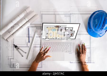 Architetto femminile che guarda i progetti di casa su laptop in ufficio Foto Stock