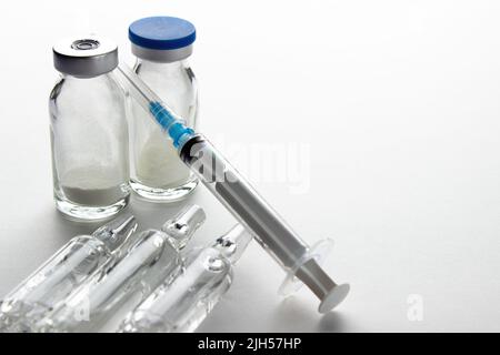 Flaconcini e siringa su un tavolo luminoso. Vaccinazione e immunizzazione Foto Stock
