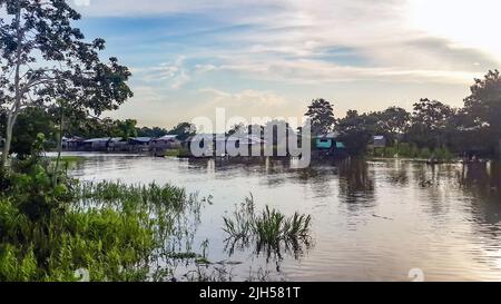 Case di palafitte costruite su pali sopra l'acqua marrone del fiume Amazzonia. Favela baraccopoli di tribù indiane locali. Scarsa protezione degli alloggi contro le alluvioni Foto Stock