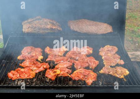Vari tipi di deliziosa carne alla griglia, tra cui bistecche, costolette di maiale e pollo, oltre al tipico barbecue americano Foto Stock