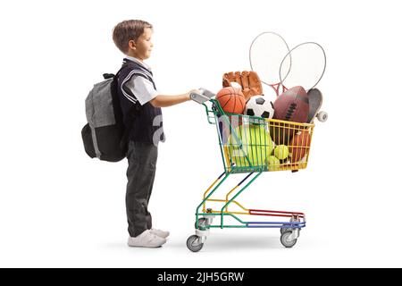 Sparo a tutto profilo di uno scolaro in uniforme con carrello pieno di attrezzature sportive isolato su sfondo bianco Foto Stock