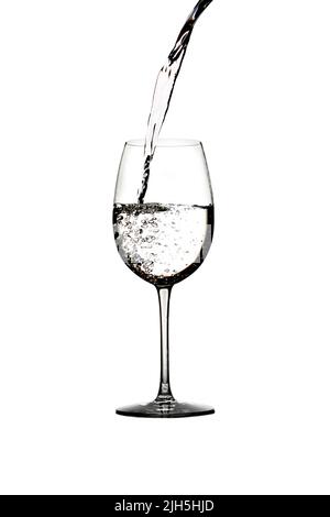 Un tuffo di acqua cristallina in un bicchiere di vino. Spruzzi d'acqua. Acqua potabile. Alcol. Isolato su sfondo bianco Foto Stock